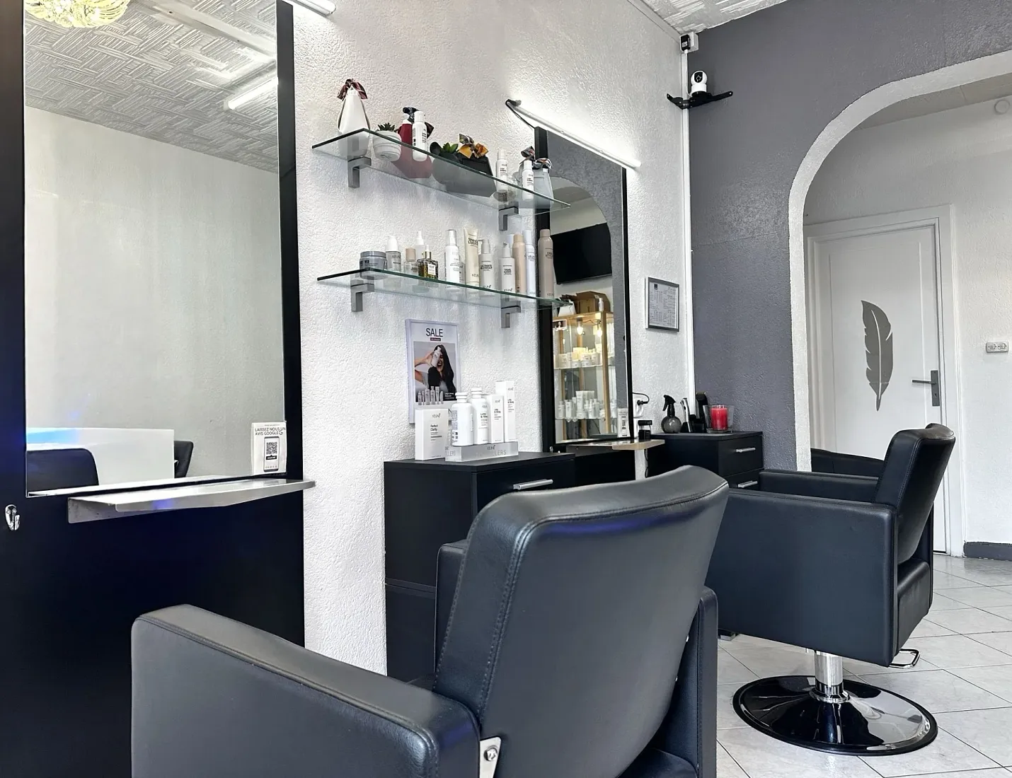 Intérieur du salon Batista Coiffure à Genève, fauteuils en cuir et étagères KEUNE